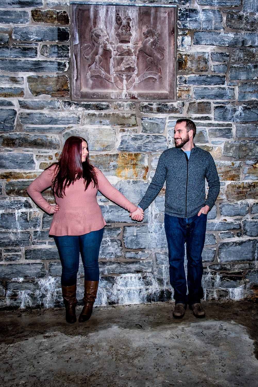 A couple holds hands during engagement photos at the Dingle Tower in Halifax, NS.