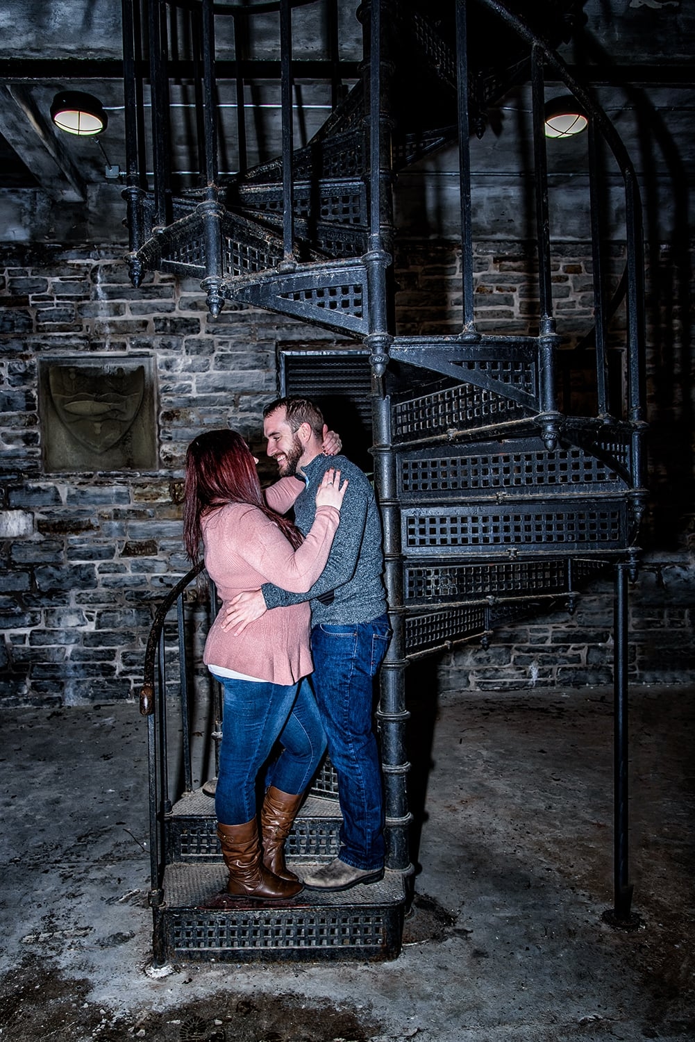 A couple in an embrace during engagement photos inside the Dingle Tower in Halifax,, NS.