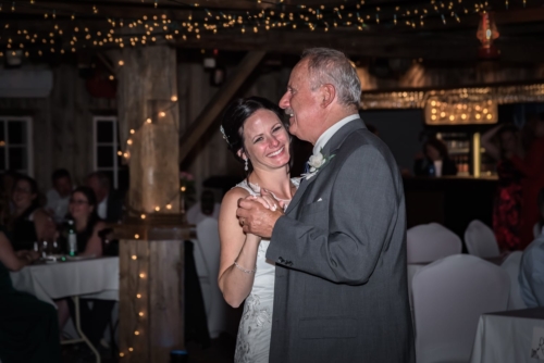 The bride dancing with her father and smiling at her Old Orchard Inn Heritage Barn wedding.