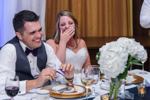 The bride and groom laughing during the wedding speeches at Juno Tower in Halifax.
