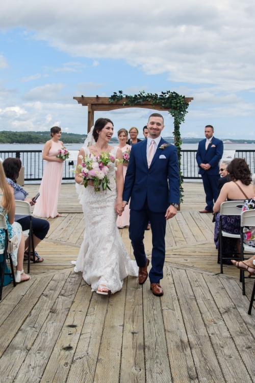 The bride and groom walking down the aisle together at a wedding in DeWolfe Park Halifax.