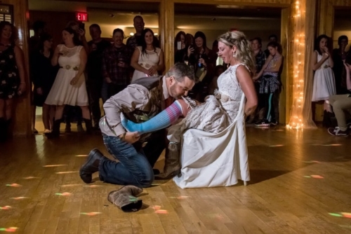 The bride and groom during the wedding garter toss at their wedding reception.