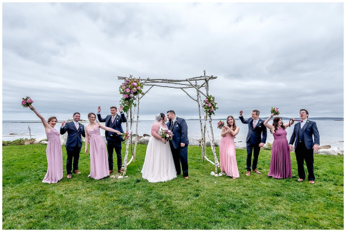 The wedding party have fun with the bride and groom while posing for wedding photos at the Oceanstone Resort in NS.