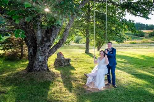 The bride and groom on a swing at sunset during their wedding at the Barn at Sadie Belle Farm in Hantsport NS.